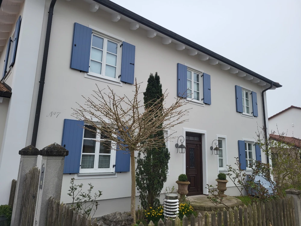 Fassadensanierung eines Hauses im Toscanastil mit blauen Fensterläden